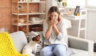 Persona con alergia al lado de un perro