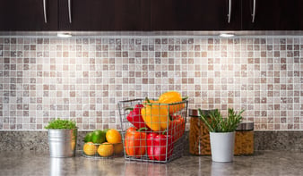 Luces instaladas en mueble de cocina sobre mesón con verduras